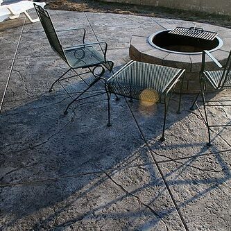 Seamless Stamped Concrete patio - natural with charcoal antiquing release agent. Firepit and patio by The Concrete Artisans, Inc